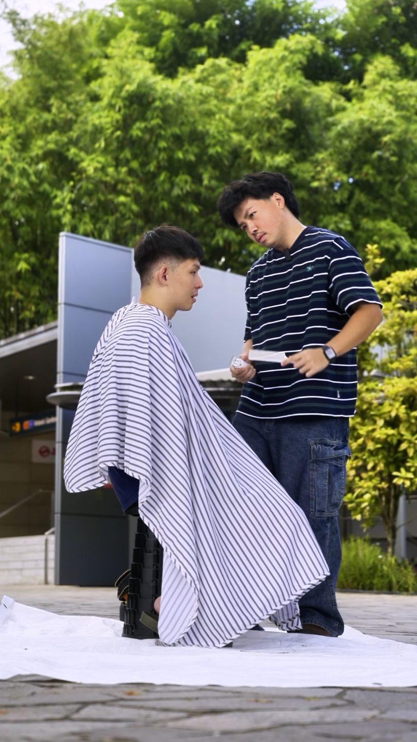A volunteer barber giving a free haircut outdoors